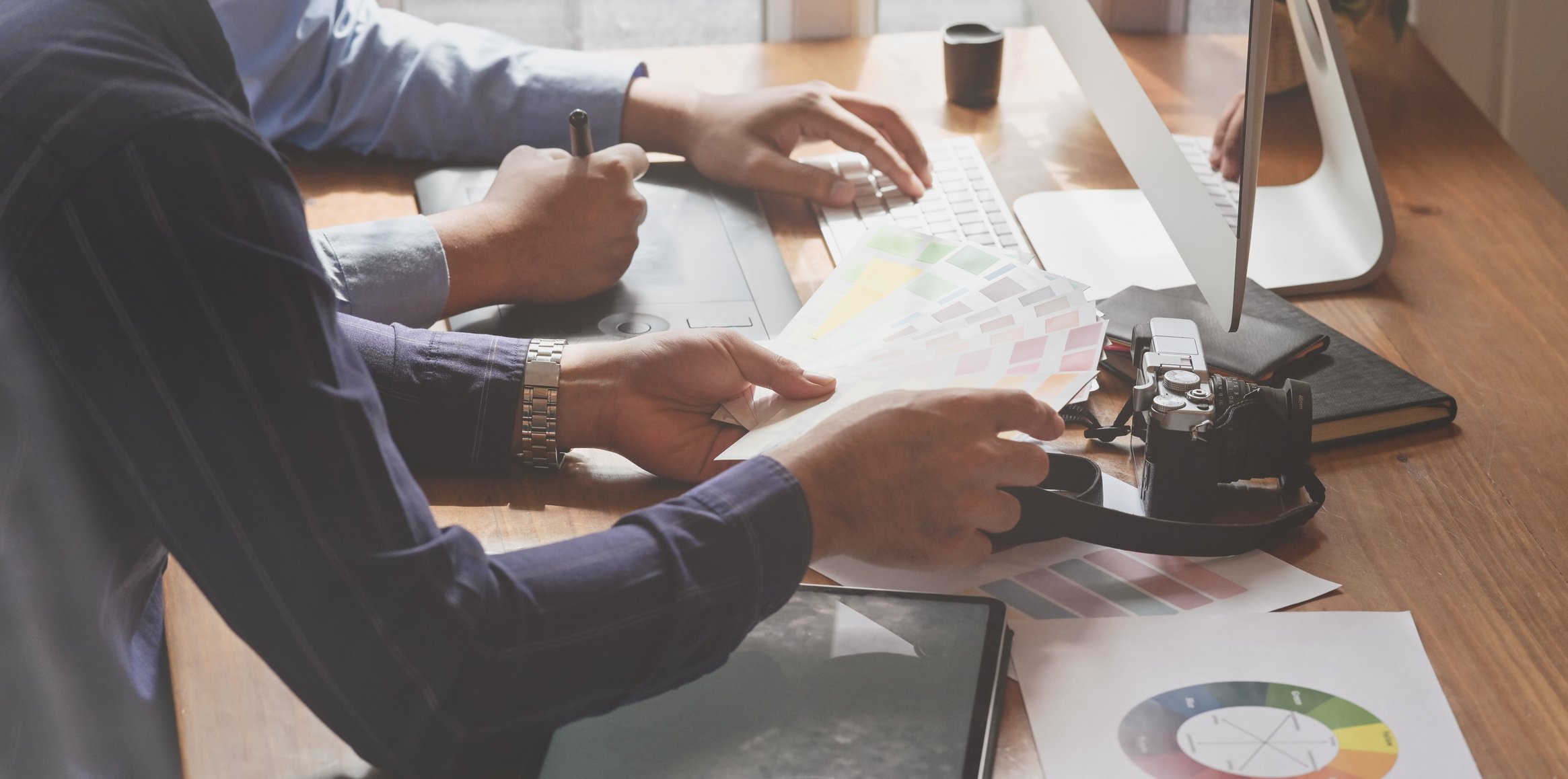 Unrecognizable partners working on design project choosing color on leaflets